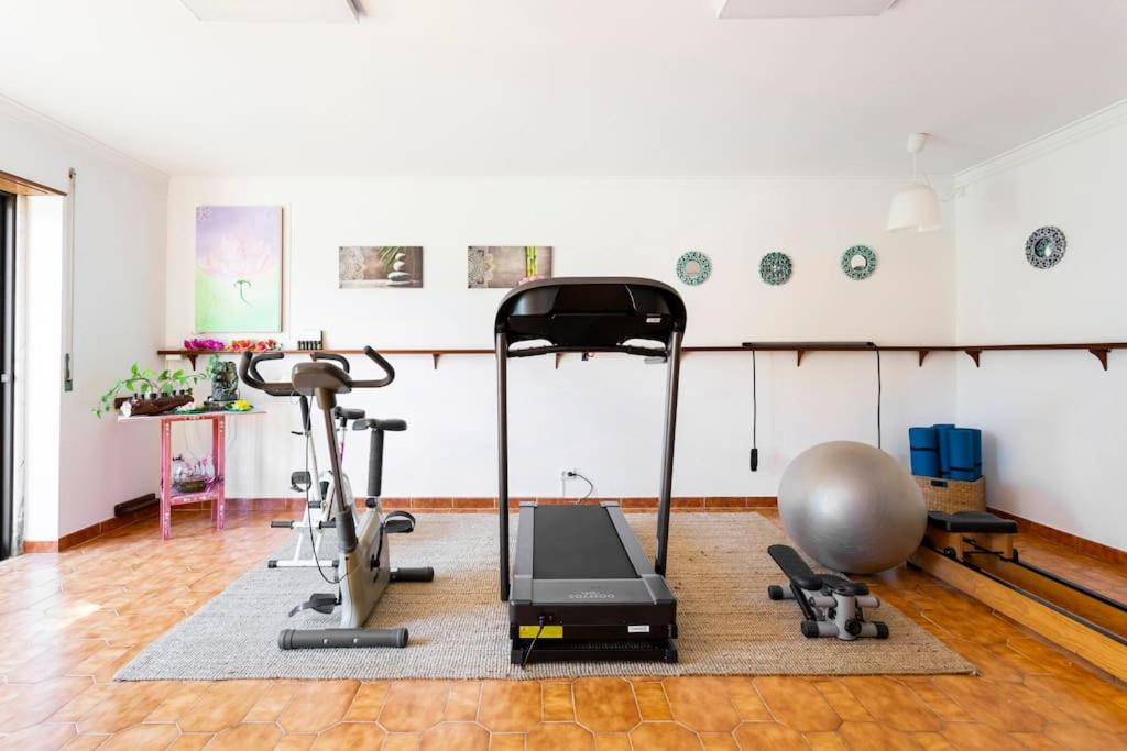 a room with a gym with a treadmill and a ball at Paradise Suites in Carcavelos