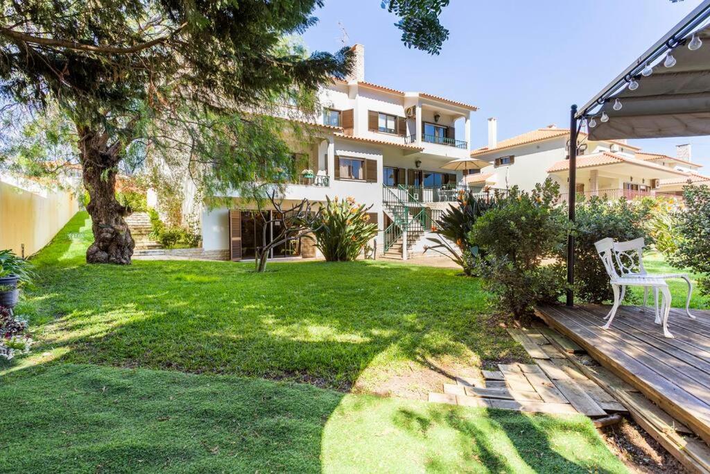 a yard with a bench and a house at Paradise Suites in Carcavelos