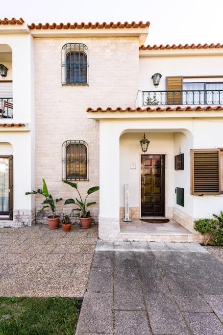 a white house with a door and a balcony at Paradise Suites in Carcavelos
