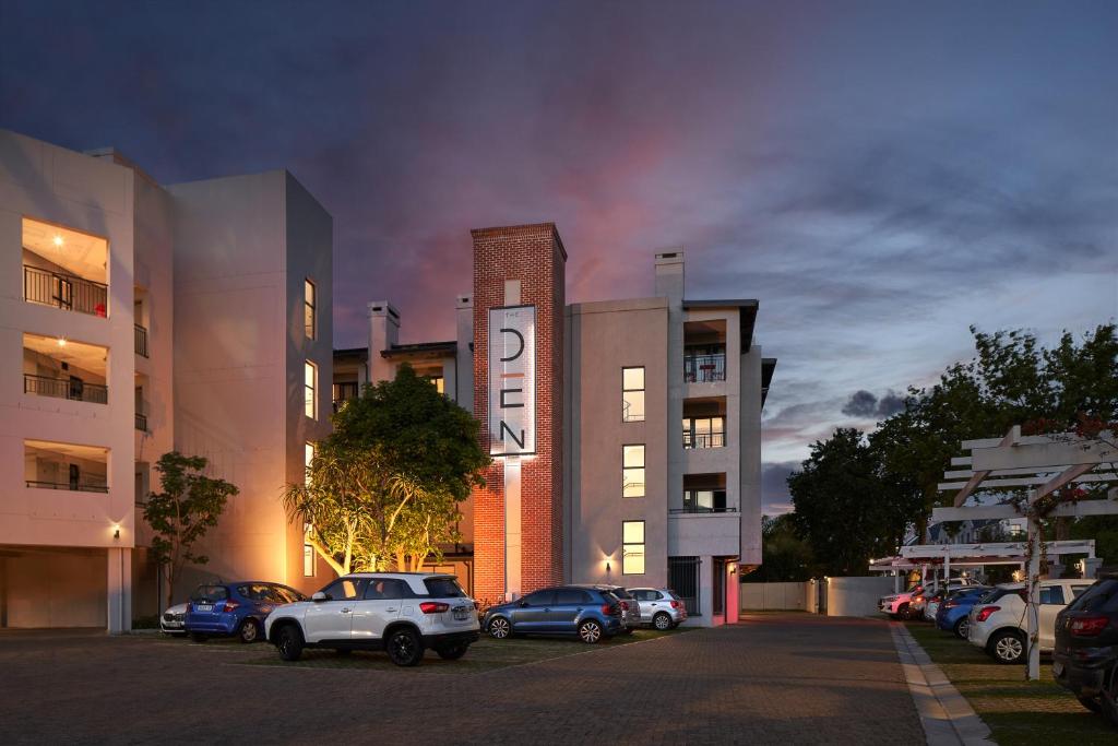 een parkeerplaats met auto's voor een gebouw bij The Den Apartments by Raw Africa Collection in Stellenbosch