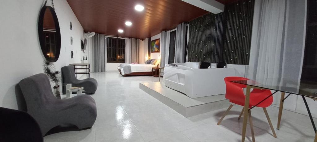 ein Wohnzimmer mit einem Tisch und roten Stühlen in der Unterkunft Hotel la casona de Wiky in Guaduas