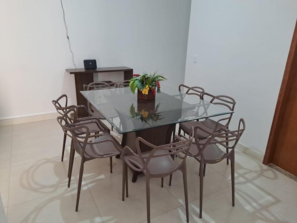 uma mesa de vidro com cadeiras e uma planta em vasos em Casa de praia em Mucuri Bahia em Mucuri