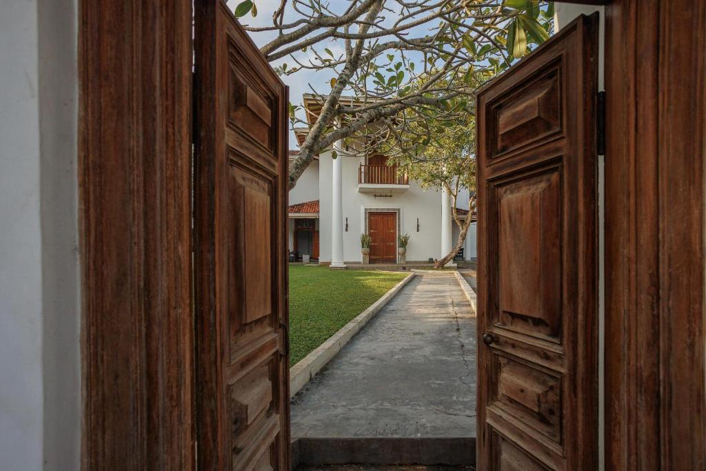 an open door to a yard with a house at Villa White Queen in Galle