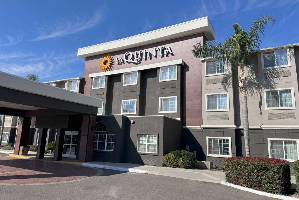 a hotel building with a sunitta sign on it at La Quinta by Wyndham Tulare in Tulare
