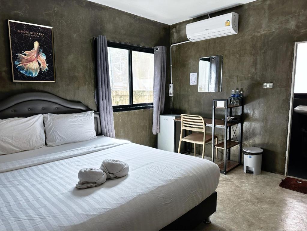 大城Taweehome hotel的一间卧室,配有一张带两顶帽子的床