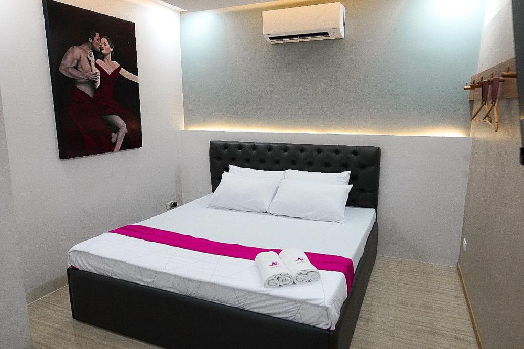 OYO 1030 Ai Hotel في مانيلا: غرفة نوم عليها سرير وفوط
