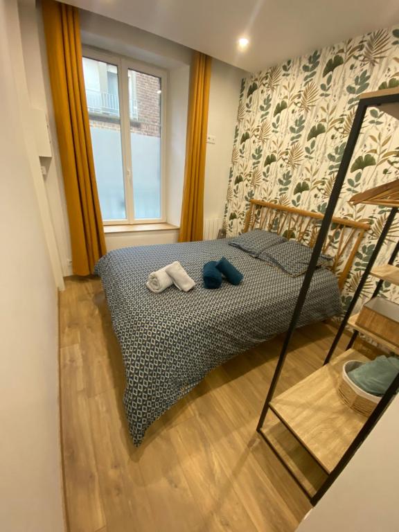 1 dormitorio con 1 cama con 2 toallas en Joli appartement F2 plein centre Coutances, en Coutances