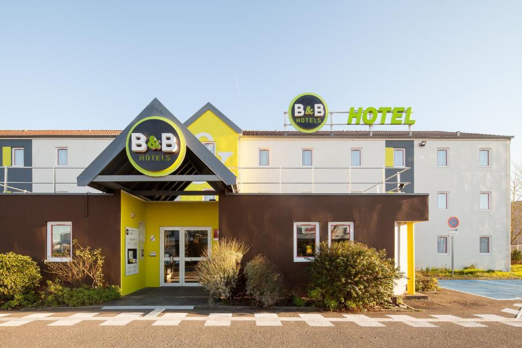 un hôtel avec un panneau à l'avant dans l'établissement B&B HOTEL Maurepas, à Maurepas