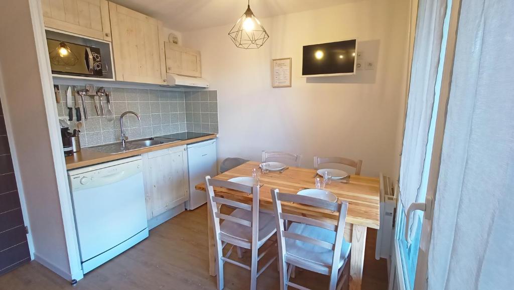 une petite cuisine avec une table et des chaises en bois dans l'établissement Studio Grand Balcon Montagne Ski et Randos, à Luz-Saint-Sauveur