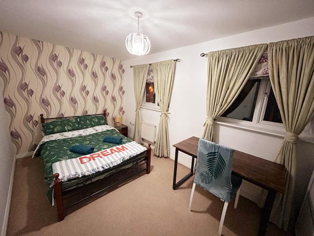 sypialnia z łóżkiem, biurkiem i oknem w obiekcie Queens Rooms, a Perfect Stay, Next to Shopping Parks and Central Manchester w Manchesterze