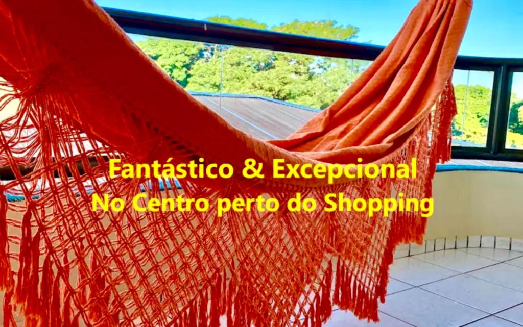 a hammock hanging from a window with a view at Apto no centro perto do Shopping com 2 Quartos ArCond WiFi Fibra HomeOffice e Garagem em Dourados in Dourados