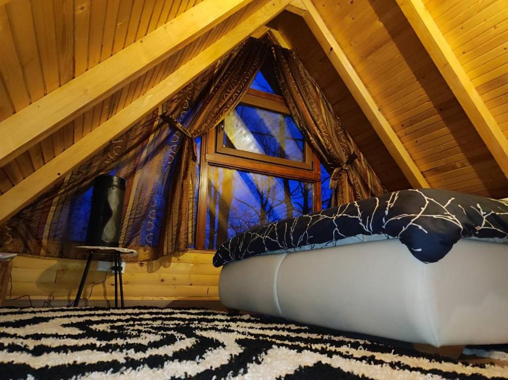 a bedroom with a large window in a attic at Vila Šibovi in Banja Luka