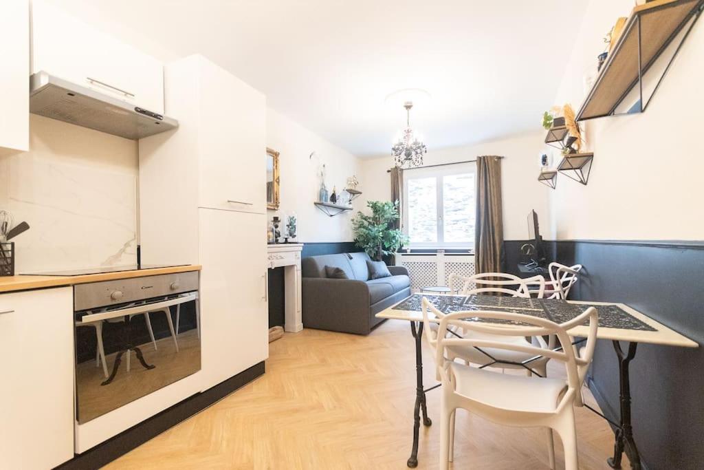 a kitchen and living room with a table and chairs at Le Cabinet de Curiosité - La Bonne Marienne in Angers