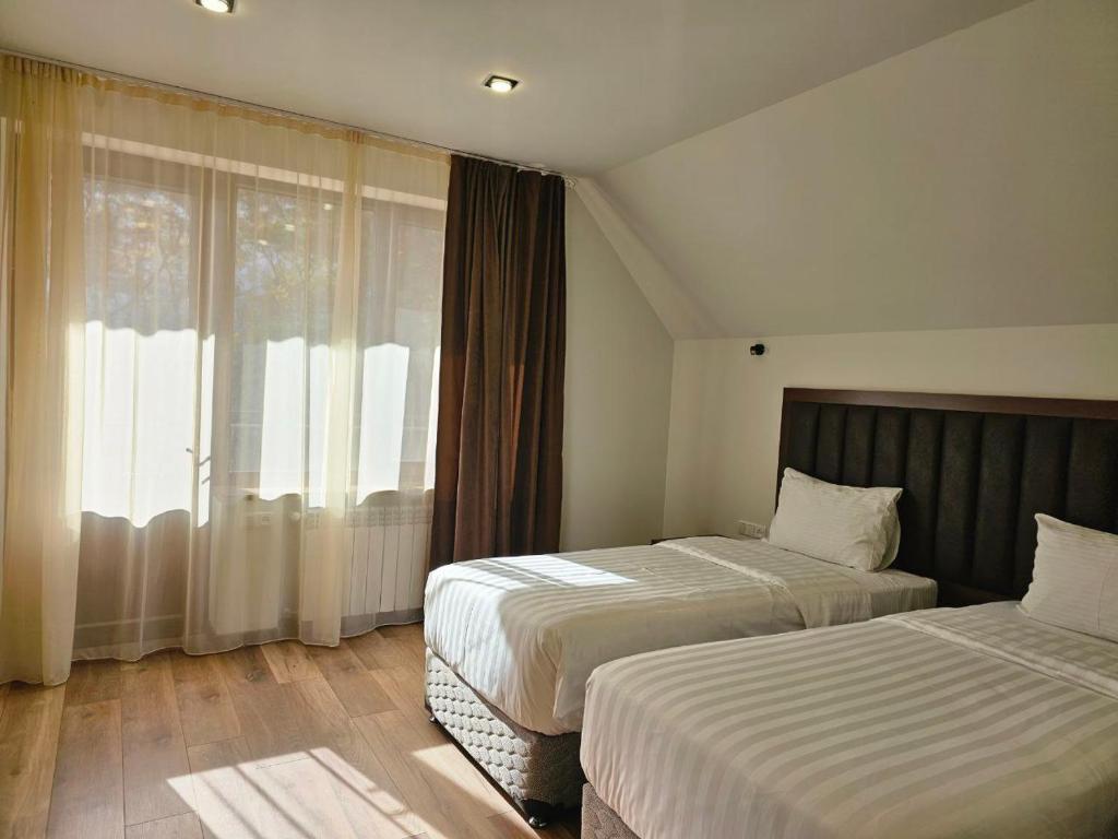 a hotel room with two beds and a window at Park Resort Aghveran in Aghveran