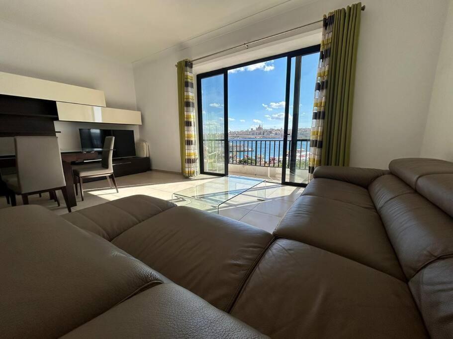 斯利馬的住宿－Sea View Over Valletta Strand Area，客厅设有棕色的沙发和大窗户