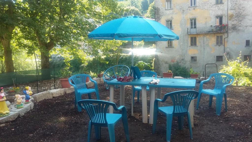 una mesa azul con sillas y una sombrilla en Labarchettaok, en Castelnuovo di Garfagnana
