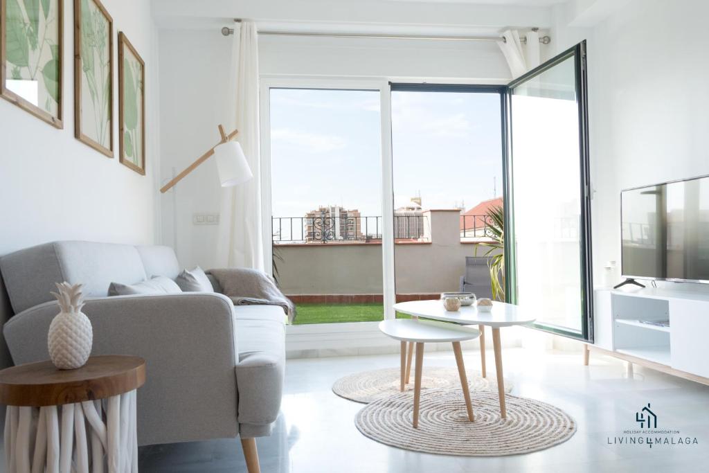 uma sala de estar com um sofá e uma mesa em Living4malaga Blue Bay em Málaga