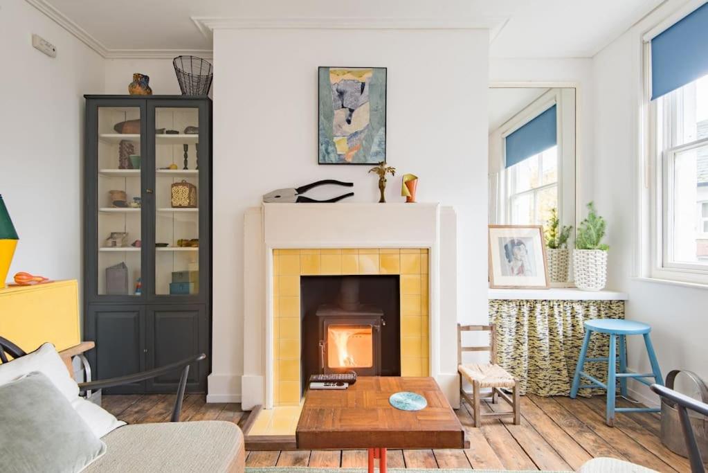a living room with a fireplace and a couch at Folkestone Terrace - quirky vibe holiday home in Kent
