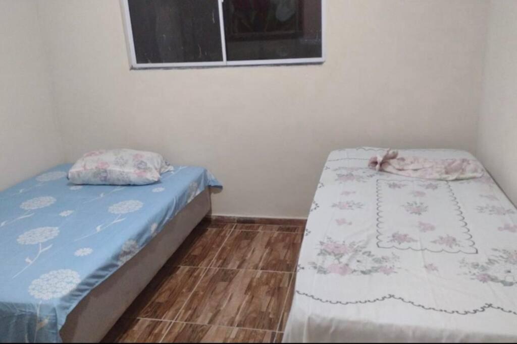 2 camas individuales en una habitación con ventana en Casa de Praia em condomínio, en Vera Cruz de Itaparica