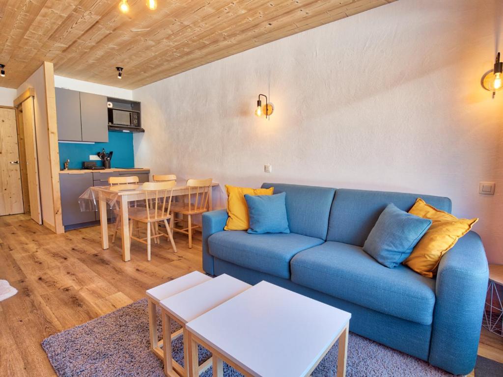 un salon avec un canapé bleu et une table dans l'établissement Studio rénové, proche pistes, parking, confort - FR-1-505-157, à Notre-Dame-de-Bellecombe