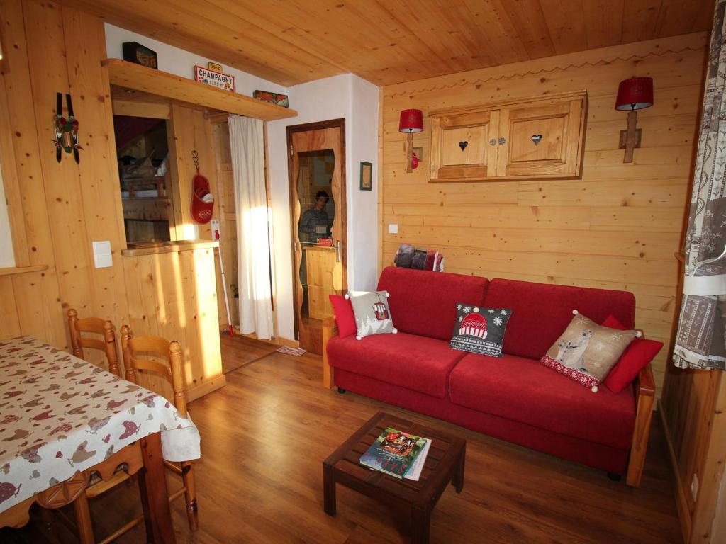 un salon avec un canapé rouge et une table dans l'établissement Joli studio cosy à Champagny, proche centre, terrasse, 4 pers., accès rapide commerces/télécabine - FR-1-464-196, à Champagny-en-Vanoise