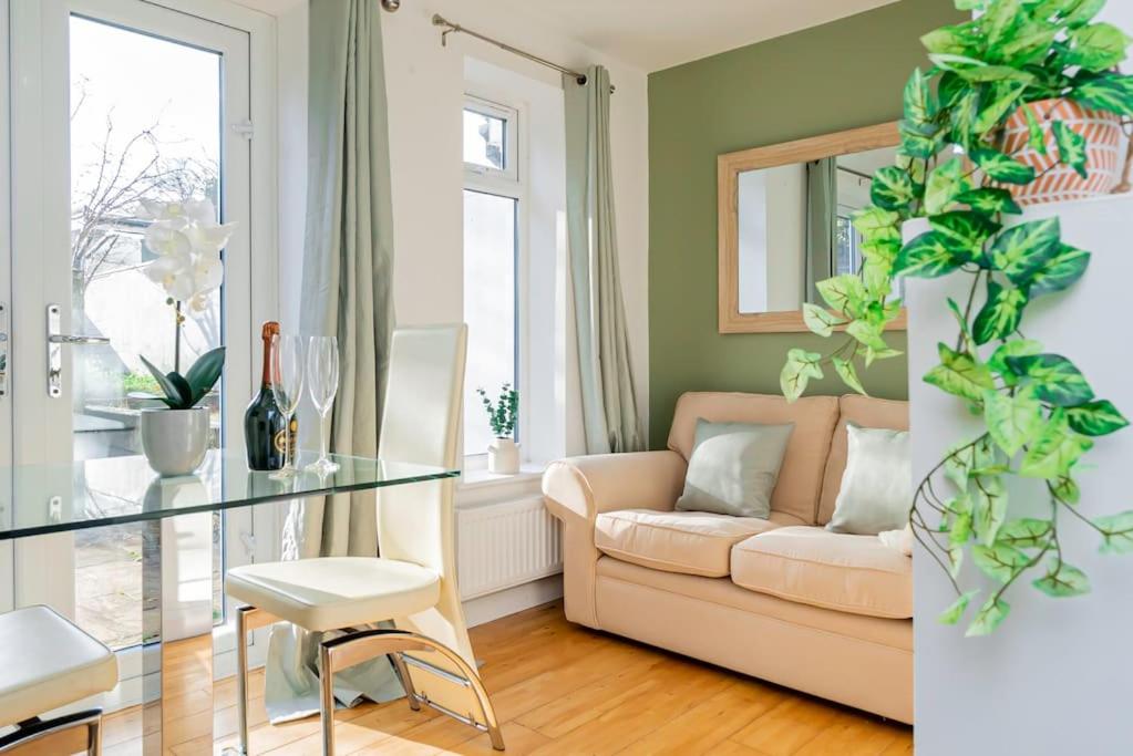 un soggiorno con divano e tavolo in vetro di Ground Floor Apartment with Free WIFI and Parking a Oxford