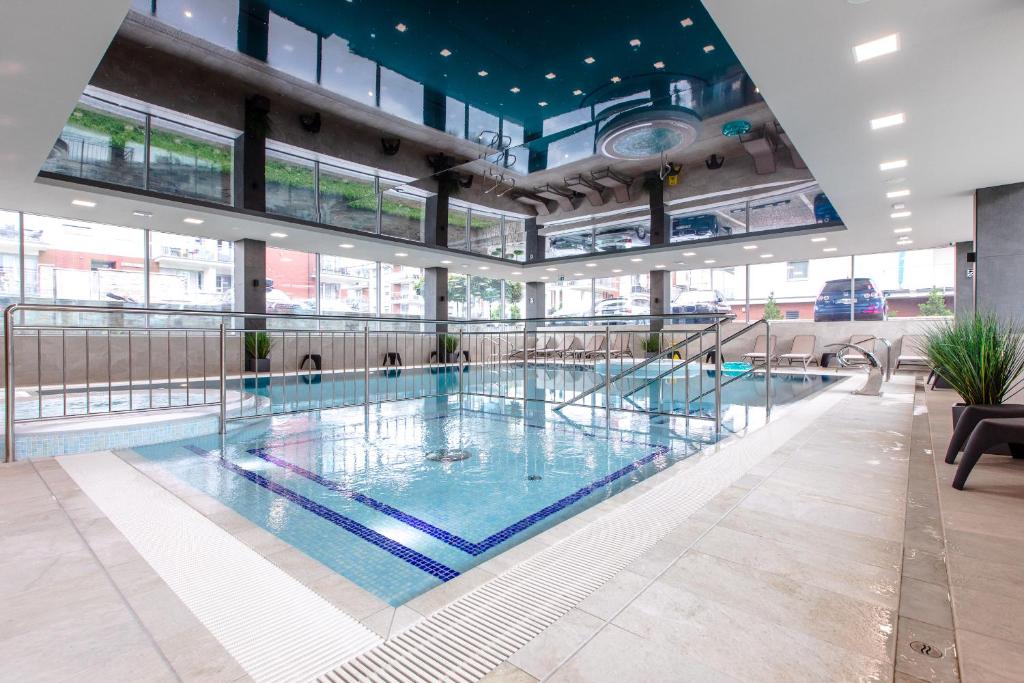 a large swimming pool in a building with windows at Resort Apartamenty Klifowa Rewal 91 in Rewal