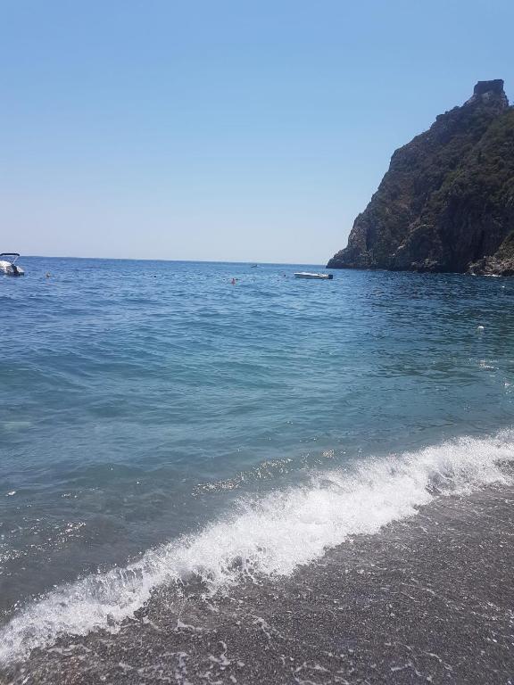 a beach with a boat in the water at SANT'ALESSIO_BAY in Santa Margherita-Sant'Alessio Siculo