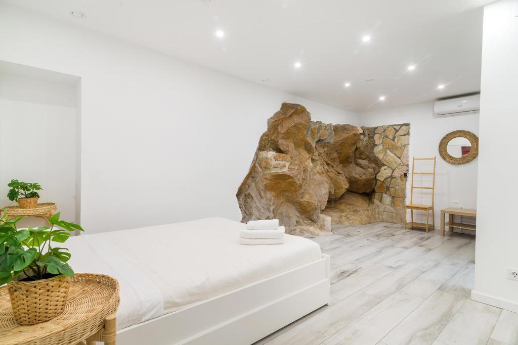 a living room with a white couch and a stone wall at Piso Costa de la Creu, 80 pasos de playa in Lloret de Mar