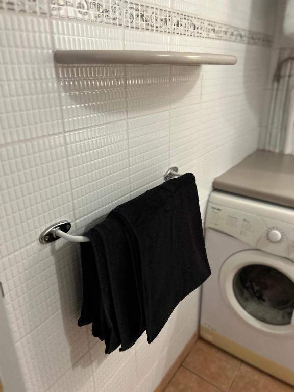 a black towel hanging on a wall next to a washing machine at TAN&#39;MAYEVA APPART * in Mamoudzou