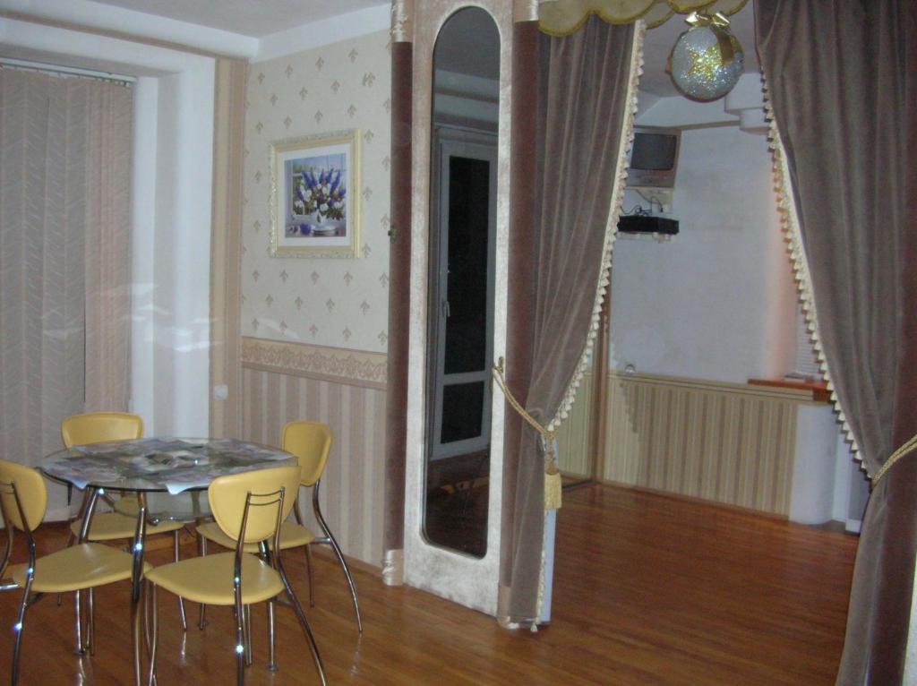 een eetkamer met een tafel en gele stoelen bij Apartments Arhitektora Artynova in Vinnytsya