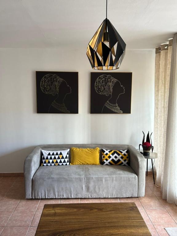 a living room with a gray couch and a chandelier at TAN&#39;MAYEVA APPART * in Mamoudzou