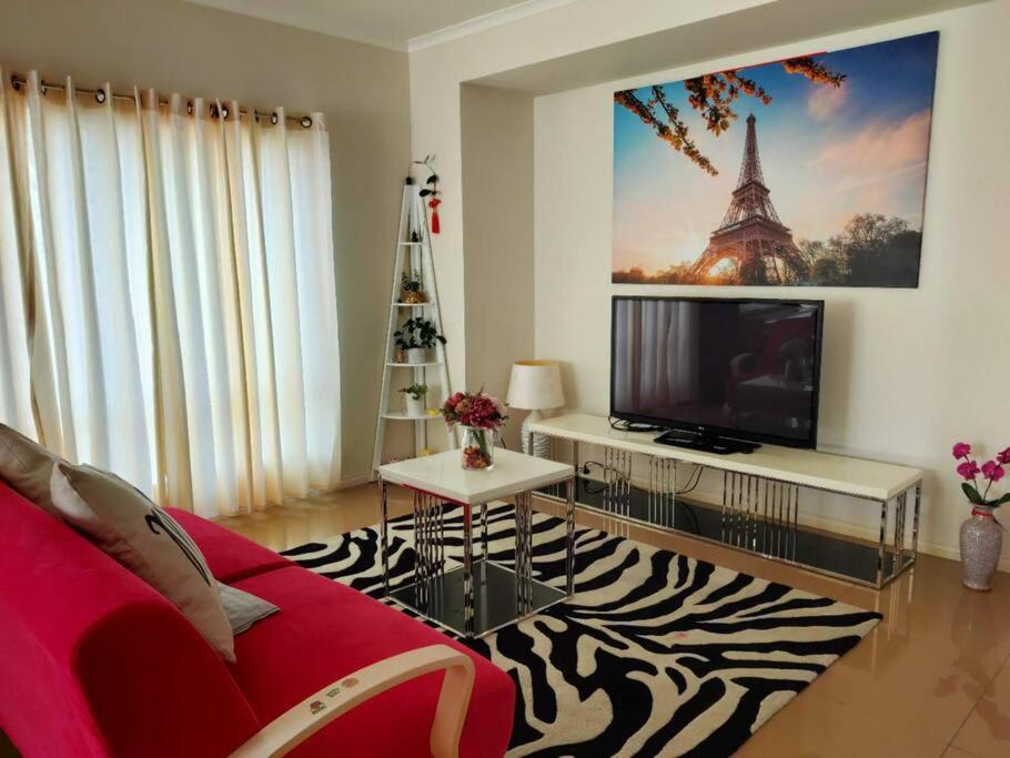 キャロライン・スプリングスにあるPrivate Guest Suite in Caroline Springsの赤いソファとテレビのあるリビングルーム