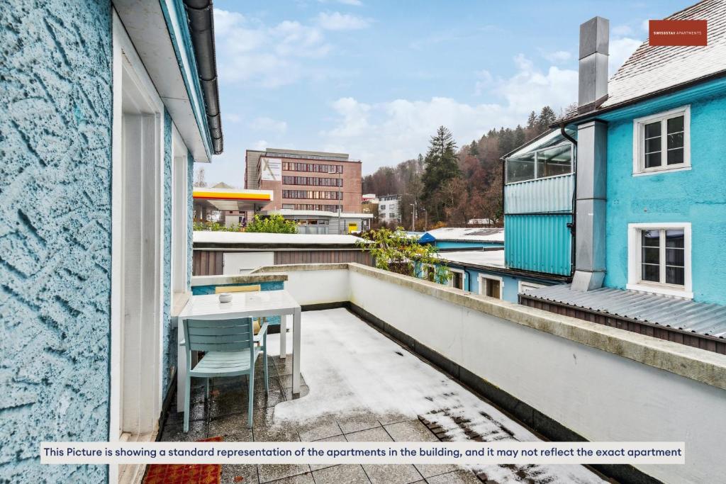 einen Balkon mit einem Tisch und Stühlen auf einem Gebäude in der Unterkunft Budget Living in the outskirts of Zurich in Dietikon