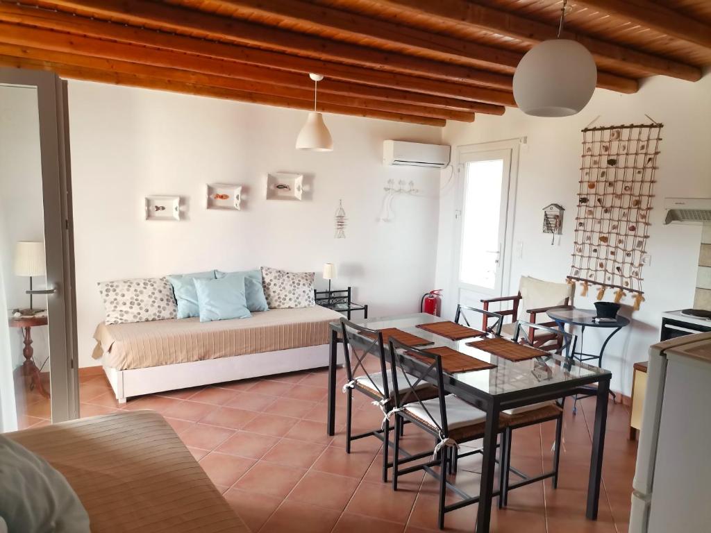 una sala de estar con una mesa y un sofá en Maroussa's Apartments, en Rámos