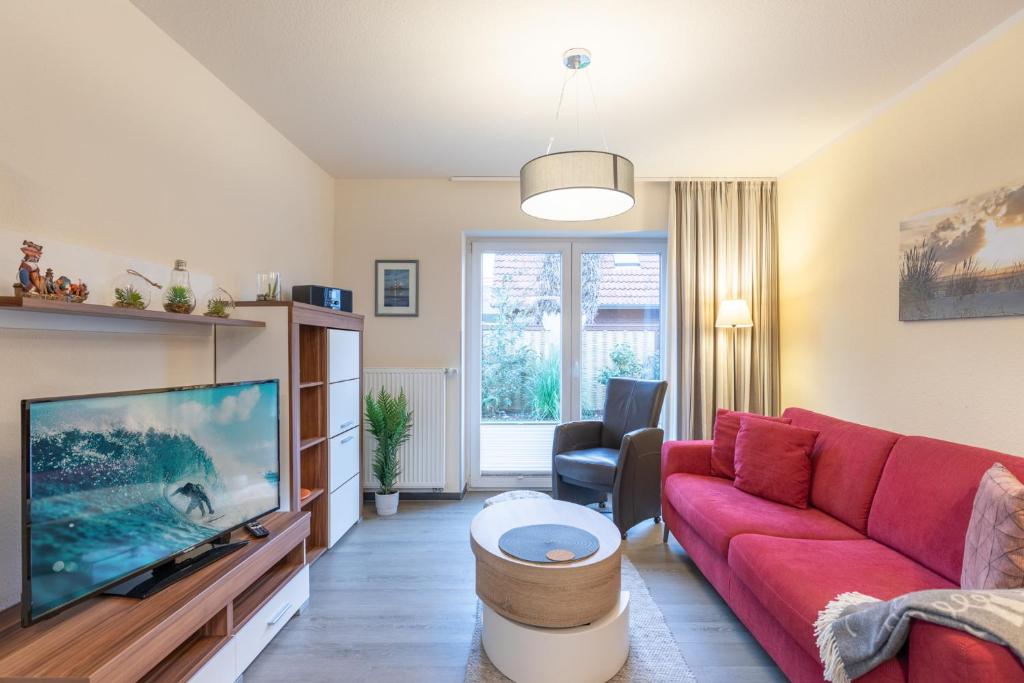 Una sala de estar con un sofá rojo y un televisor. en Seute Deern, en Olsdorf