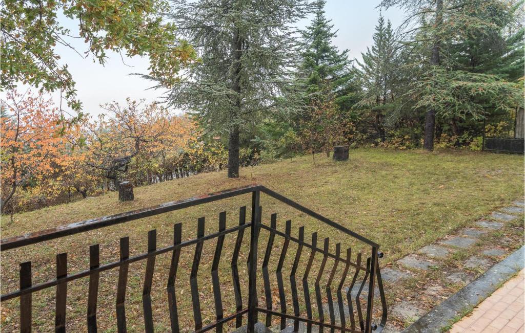a black iron fence in a park with trees at Beautiful Home In Cerqueto Di Civitella With House Sea View 