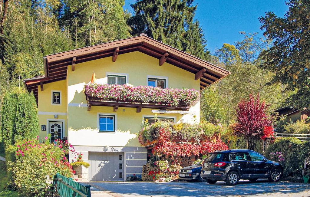 um carro estacionado em frente a uma casa com flores em Amazing Apartment In Wagrain With Wifi em Wagrain