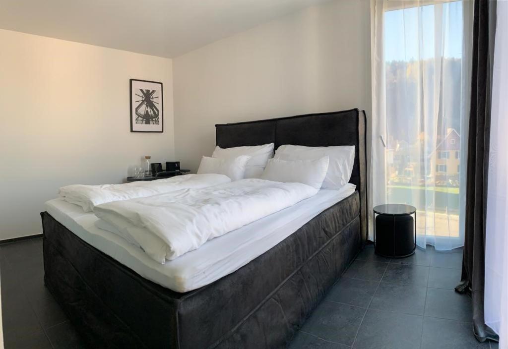 a large bed in a bedroom with a large window at Motel by Maier Feldkirch - kontaktloser Check-in in Feldkirch