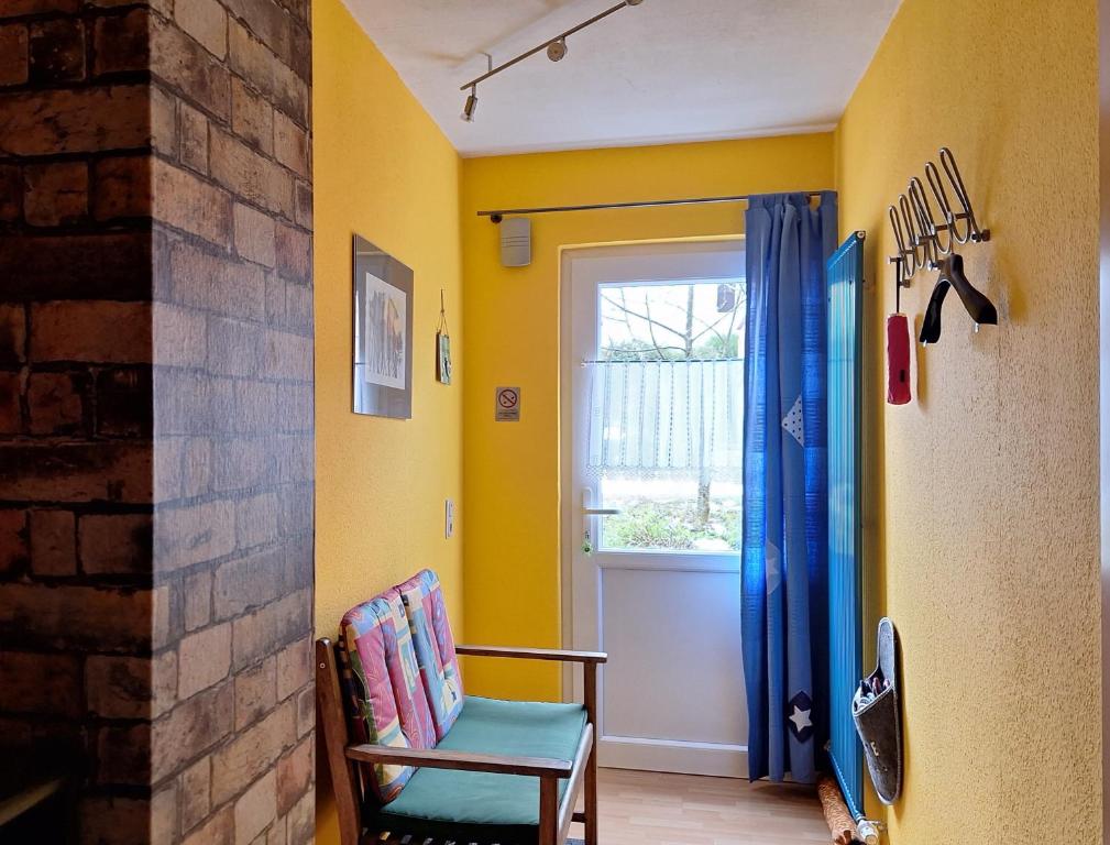 a yellow room with a chair and a window at Ferienwohnung Marlene Conrad in Eppelborn