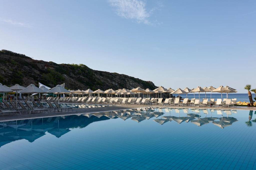 basen z leżakami i parasolami oraz ocean w obiekcie Atlantica Mikri Poli Crete w mieście Makry Gialos