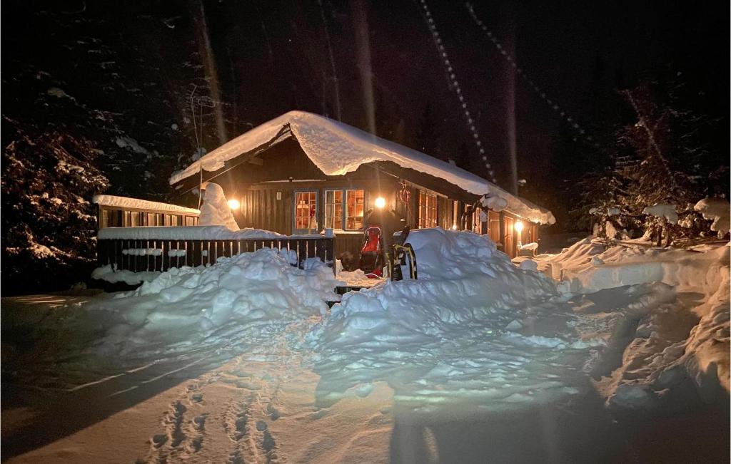 a house covered in snow at night with lights at Stunning Home In Aurdal With House A Mountain View in Aurdal