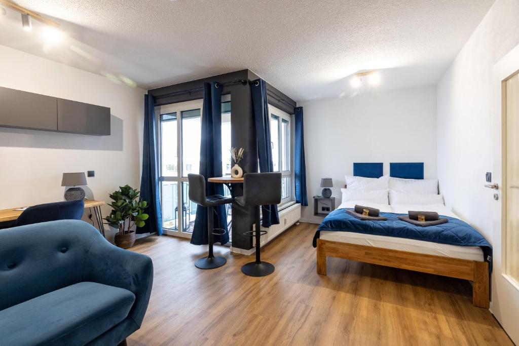 a bedroom with a bed and a couch and a table at Sunnybelle Appartements Dresden I in Dresden