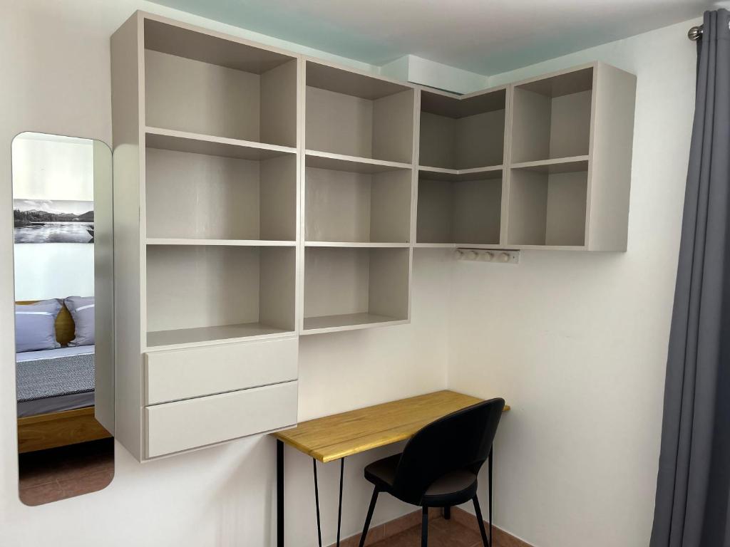 a bedroom with white cabinets and a desk and a chair at TAN&#39;MAYEVA APPART * in Mamoudzou