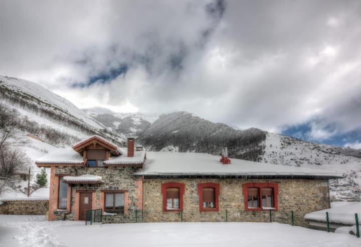 a house with snow on top of it in the mountains at Posada Real Pajares in Pajares