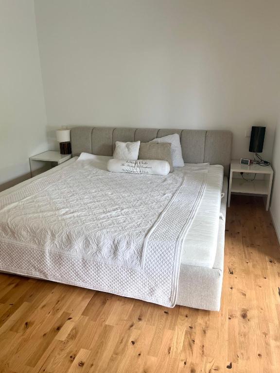una camera da letto con un grande letto bianco con due tavoli di Wohnung am Wald a Geisa