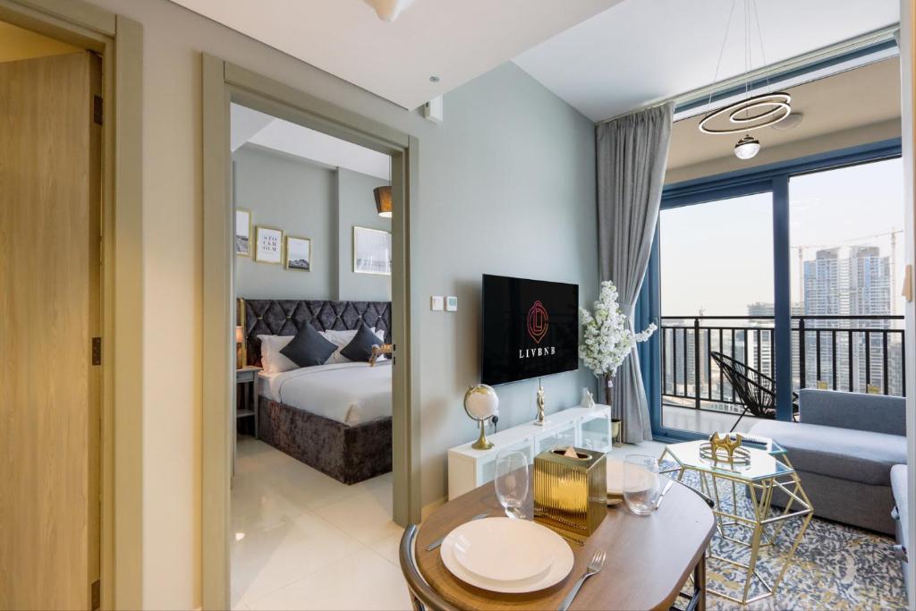 a hotel room with a king sized bed and a balcony at Canalfront Gem: 1BR in Zada Tower by Livbnb in Dubai