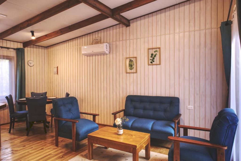 a waiting room with blue chairs and a table at Cabaña Los Mañios in Puerto Montt