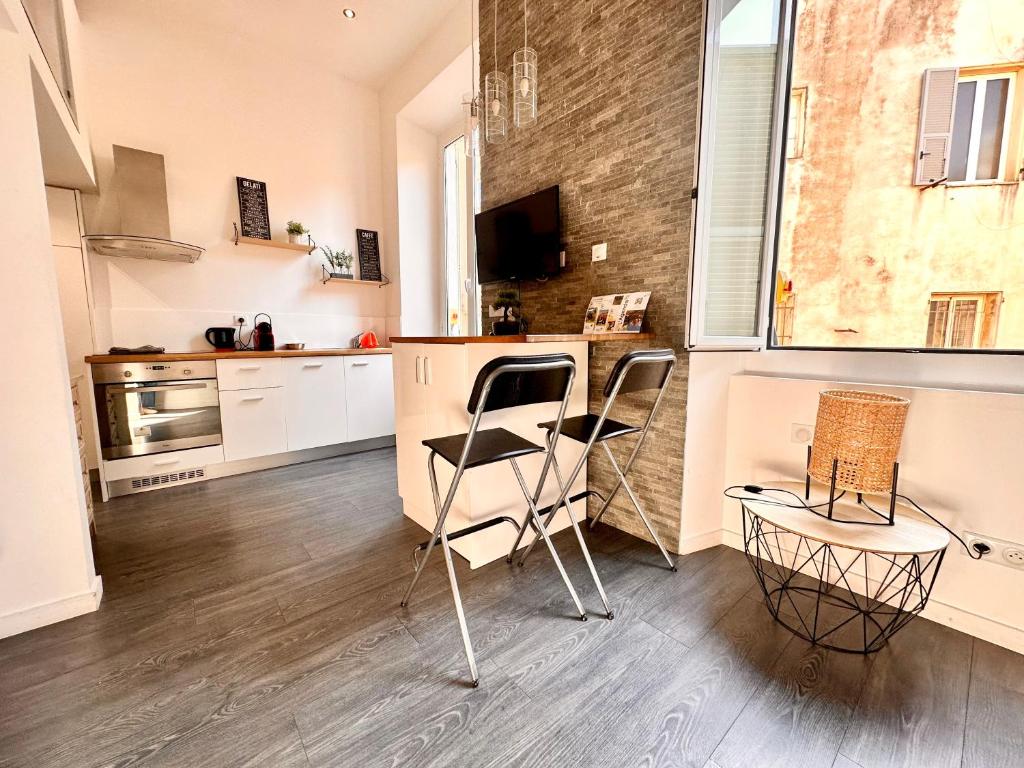 - une cuisine avec 2 chaises et un comptoir dans une pièce dans l'établissement Sweet Loft centre ville de Menton, à Menton