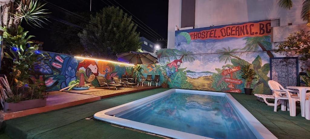 una piscina con un mural en el lateral de un edificio en Oceanic Hostel, en Balneário Camboriú